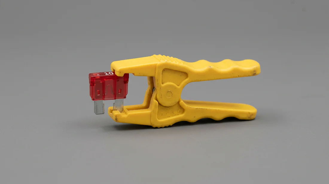 Utilisation d'une pince pour extraire un fusible de voiture